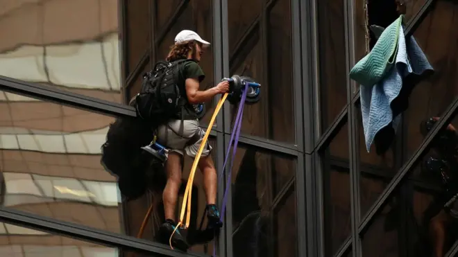 Agentes del Departamento de Policía de Nueva York quitaron algunas ventanas para intentar detener al escalador en su subida.