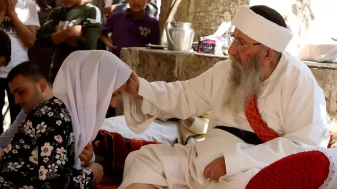 " الشيخ الإيزيدي الكبير" يبارك امرأة في "عيد ئيزي" بعد ثلاثة أيام من الصيام. أكتوبر/تشريم الأول 2017 في معبد لالش بإقليم كردستان العراق