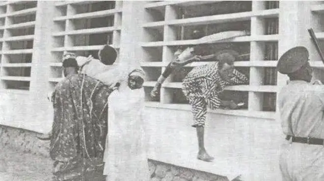 Aworan atijọ alawọ funfun to se afihan bi awọn eeyan se n fo oju ferese lati sa fun laasigbo, ti ọlọpaa kan pẹlu kondo lọwọ si n le wọn