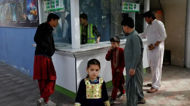 A little girl stands in front of a ticket booth in an amusement park in Kabul, Afghanistan, November 9, 2022.