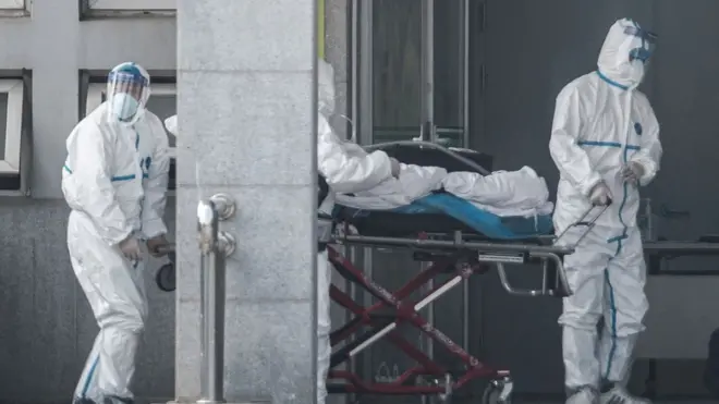 Medical staff members carry a patient into the Jinyintan hospital, where patients infected by the virus are being treated, in Wuhan in China's central Hubei province on January 18, 2020
