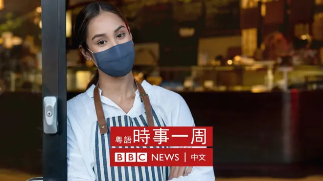 一位女服務員戴著口罩站在餐廳門口
