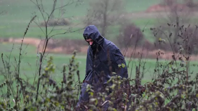 Представник польських правоохоронних структур оглядає місцевість поблизу місця падіння ракети в Пшеводові