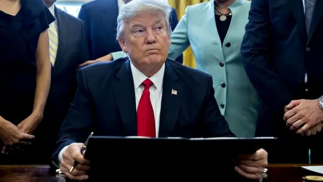 President Donald Trump pauses after signing an executive order in the Oval Office of the White House