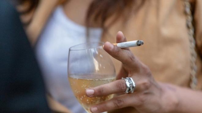 Mujer bebiendo y fumando