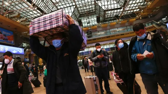 People walk with their luggage in Beijing
