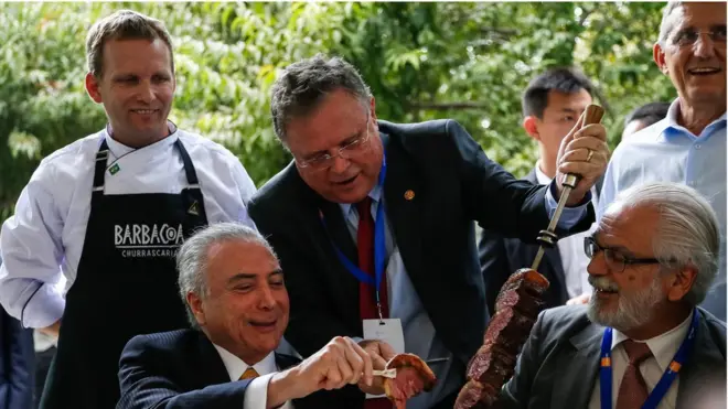 Temer é servido pelo ministro da Agricultura, Pecuária e Abastecimento, Blairo Maggi, durante churrasco. Foto: Marcos Corrêa