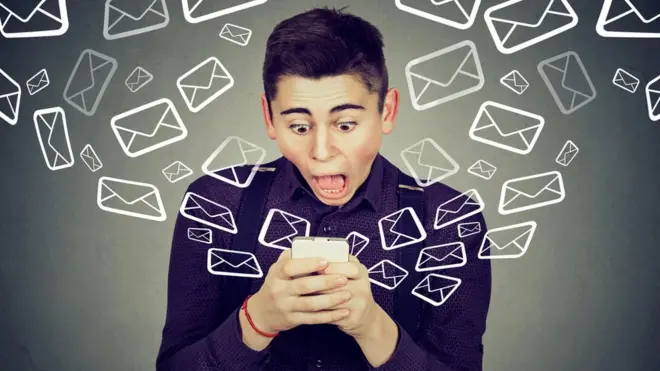 Un chico con su celular y cara de susto