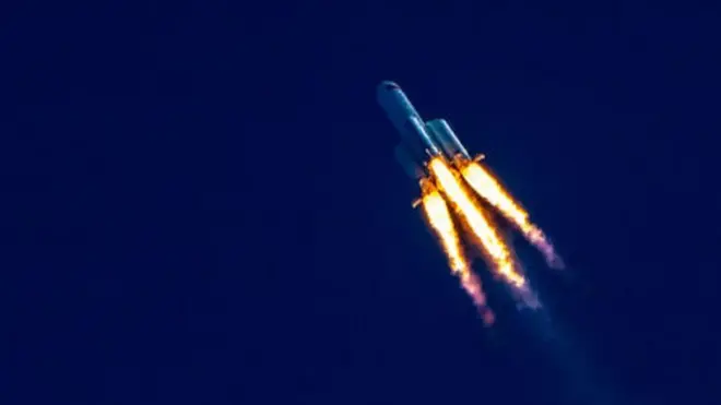 火箭帶著火焰在深藍色的天空前斜著飛行