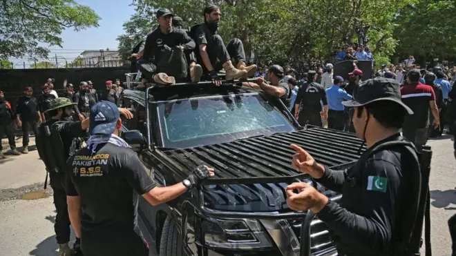 أفراد أمن يرافقون سيارة تقل رئيس الوزراء الباكستاني السابق عمران خان أثناء وصوله إلى المحكمة العليا في إسلام أباد في 9 مايو/أيار 2023.
