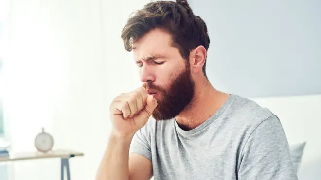 A man coughing