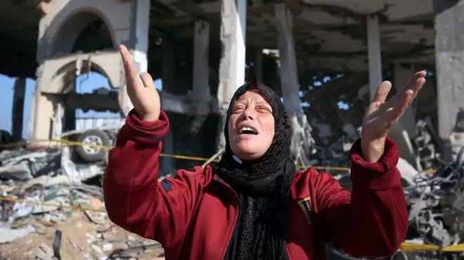 A Palestinian woman in front of a destroyed building in the Al-Maghazi refugee camp in the central Gaza Strip on January 16, 2024,