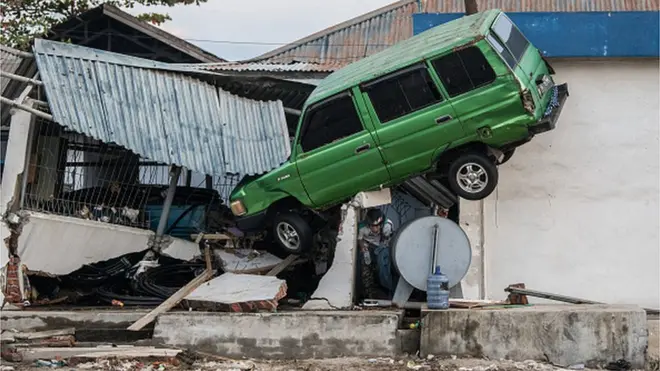 సునామీ కారణంగా అలల ధాటికి కూలిన ఇల్లు, అందులో చిక్కుకున్న కారు