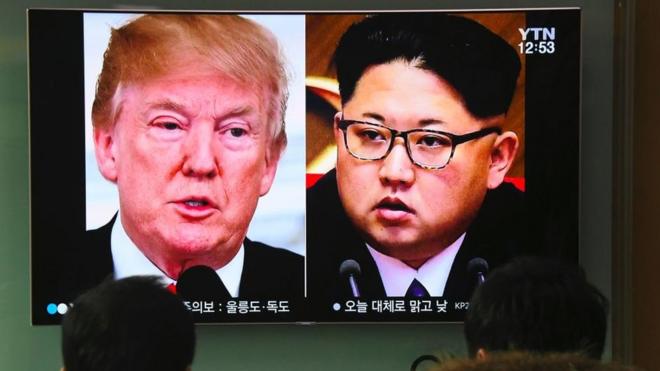 People watch a television news report showing pictures of US President Donald Trump (L) and North Korean leader Kim Jong Un at a railway station in Seoul on March 9, 2018