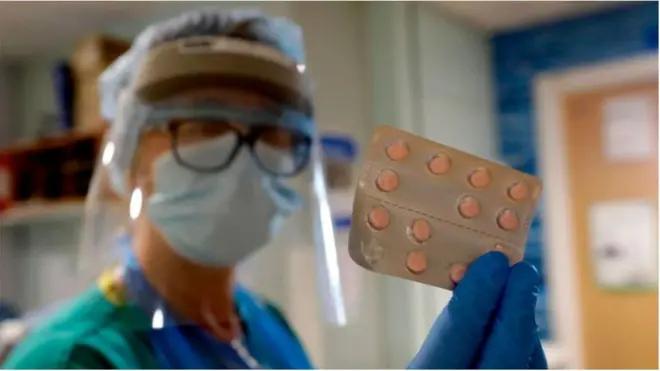 عاملة طبية تحمل شريط أقراص من دواء