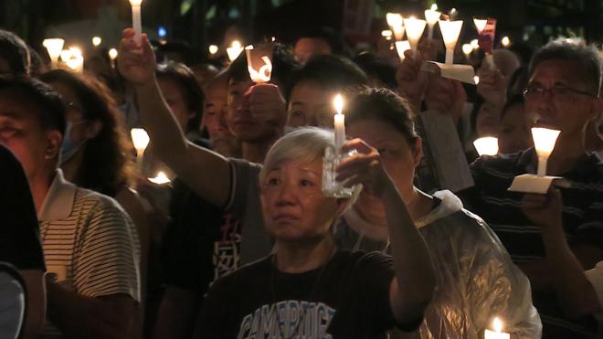 香港维园“六四”129周年烛光晚会参与群众举起手中蜡烛（BBC中文图片4/6/2018）