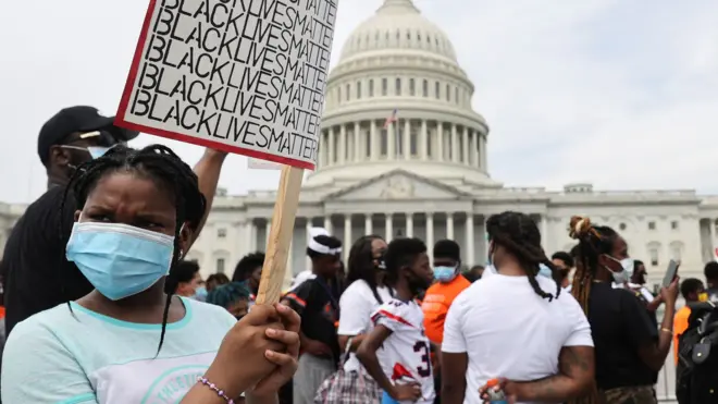 A young protester holds up a sign saying "Black Lives Matter" near the US Capitol in Washington (6 June 2020)