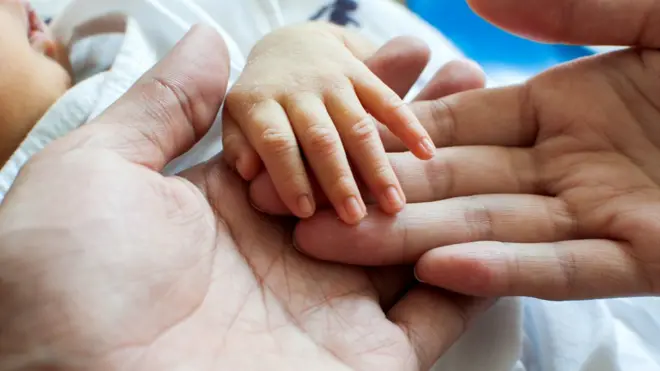 baby's hand being held