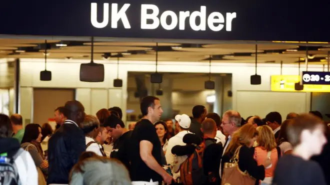 عدد من المسافرين ولافتة الحدود البريطانية