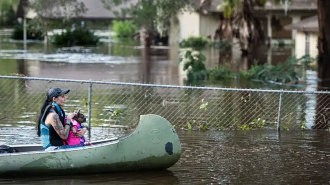дівчина в човні з собакою після урагану "Ірма"