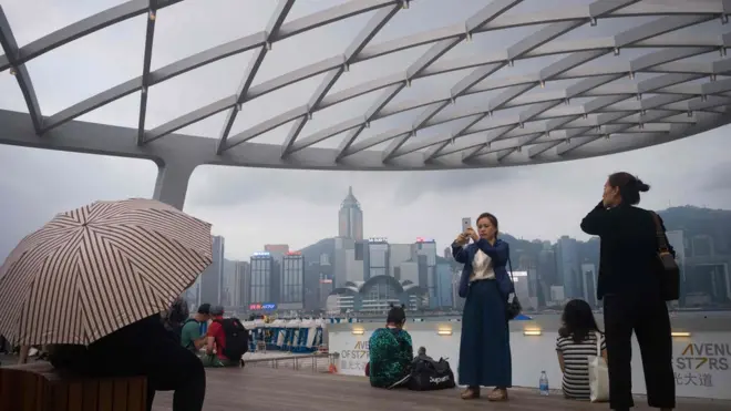 Khách du lịch chụp ảnh Cảng Victoria ở Hong Kong.