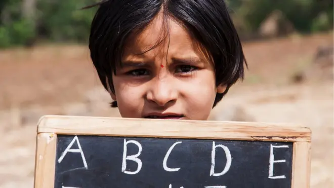 పలకపై ఏబీసీడీలు రాసిన బాలిక