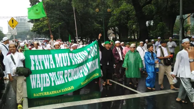Massa yang hendak menghadiri acara dzikir dan tausiah di Masjid Istiqlal, Jakarta, mengusung spanduk bernada politik.