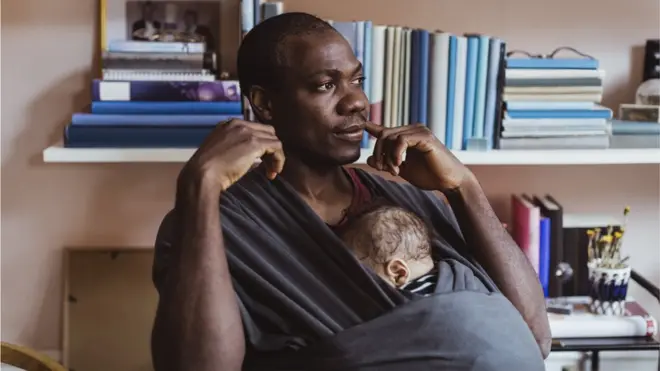 Un père avec un enfant couché contre sa poitrine