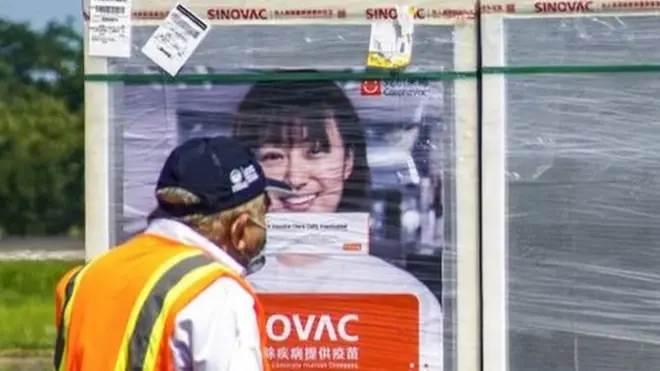 在萨尔瓦多，物流工人将装有中国产科兴疫苗的包裹装上卡车。