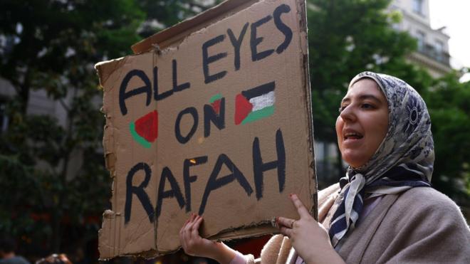 A pro-Palestinian demonstrator holds a placard reading 'All eyes on Rafah' as protesters gather outside the Sorbonne University, where they tried to set up a protest camp before being evacuated by police in Paris, France, 29 April 2024.