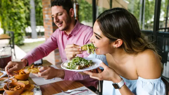 Una pareja joven comiendo comida mexicana.