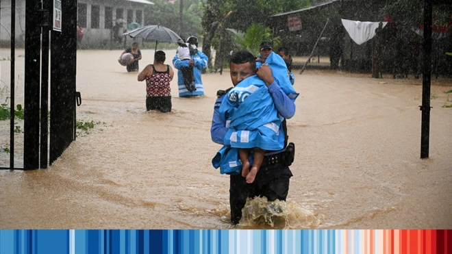 Un hombre en Honduras rescata un niño de una zona inundada tras el paso de un huracán en 2020