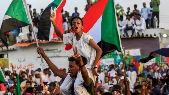سودانيون يحتفلون عقب الإعلان عن التوصل إلى اتفاق تقاسم السلطة