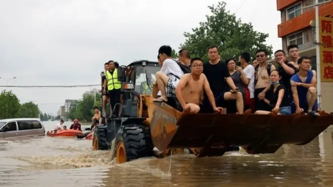 جا به جا کردن افراد به کمک لودر در شهر ژنگ‌ژو استان هنان ؛ حدود ۴۰۰ هزار نفر مجبور به ترک خانه های خود شدند