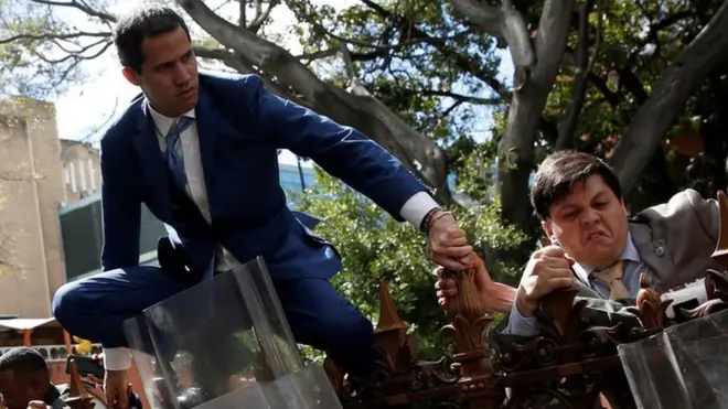 Juan Guaidó salta la verja para intentar ingresar a la Asamblea Nacional de Venezuela.