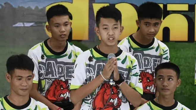 PornchaiÂ Khamluang (tengah), salah satu dari 12 anak laki-laki yang diselamatkan, berbicara di konperensi pers di Chiang Rai (18 Juli).