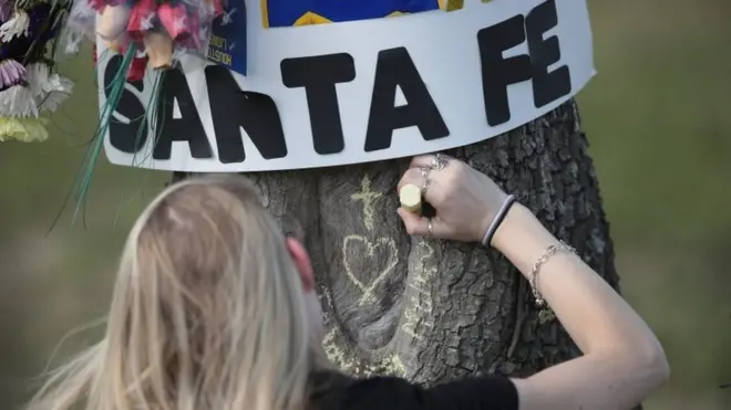 Student chalks a message on a tree outside Santa Fe High School, TX 19 May 2108