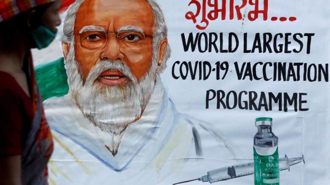 Man walking past a poster of PM Modi in Mumbai