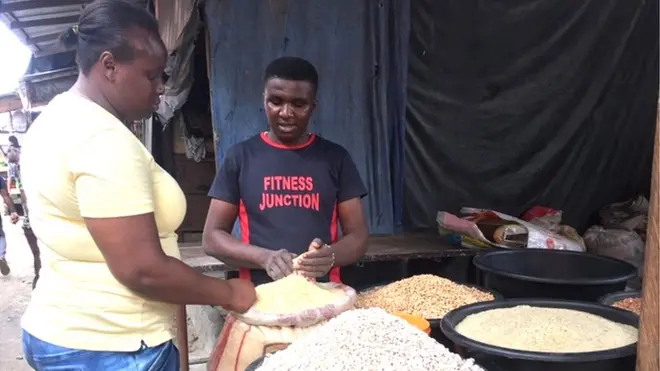 woman dey buy rice for market