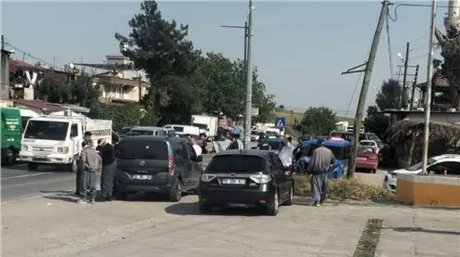 sokakta park etmiş araçlar ve kenarda durup bakan insanlar
