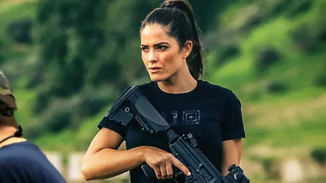 A woman carries a rifle at the NRA's 2018 annual conference in Dallas