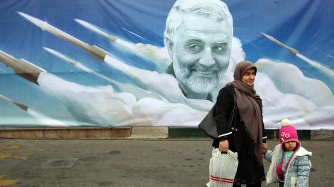 امرأة إيرانية وطفلتها وقفتنا لالتقاط صورة لهما أمام ملصق جداري يحمل صورة قاسم سليماني في طهران.