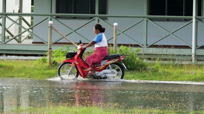 Mujer andando en moto sobre agua