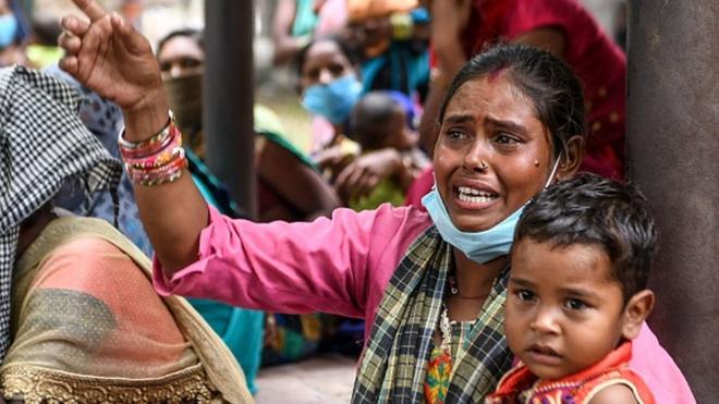 印度旁遮普邦阿姆利则市一位移民工妇女抱着孩子参加抗议政府防疫措施集会（3/6/2020）