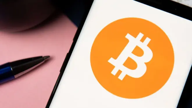 شعار عملة بيتكوين على شاشة هاتف جوال