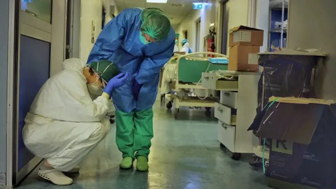 One hospital staff member consoles another in a corridor