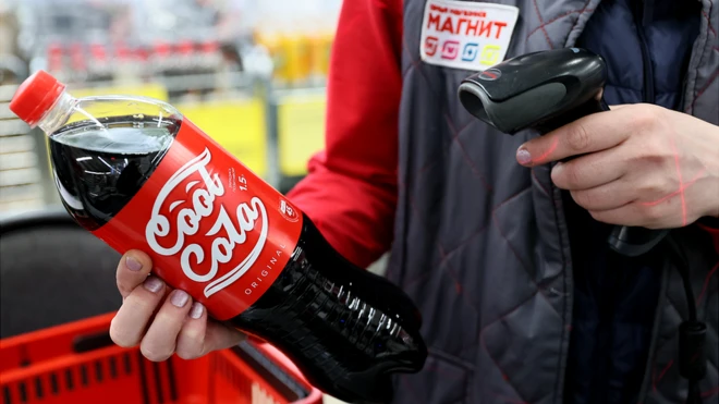 Работник магазина "Магнит" с бутылкой газированного напитка в руке