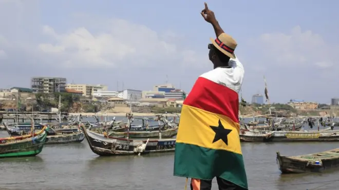 Ghana man stand wit flag