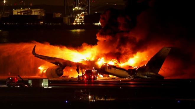 羽田空港の滑走路で燃え上がる日本航空機（2日）