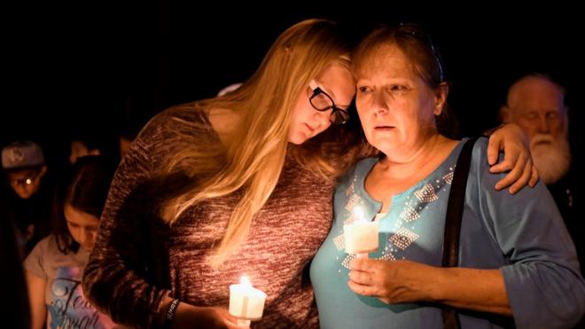 Local residents embrace during a candlelight vigil for victims of a mass shooting in a church in Sutherland Springs, Texas, U.S., November 5, 2017. REUTERS/Mohammad Khursheed